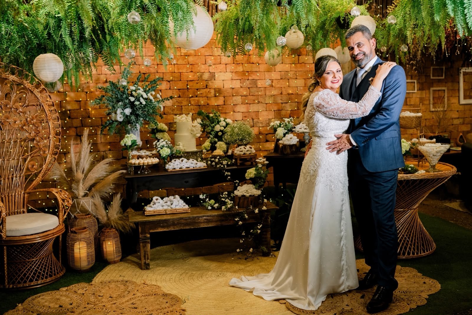 Casal de noivos abraçado diante da decoração do mini wedding